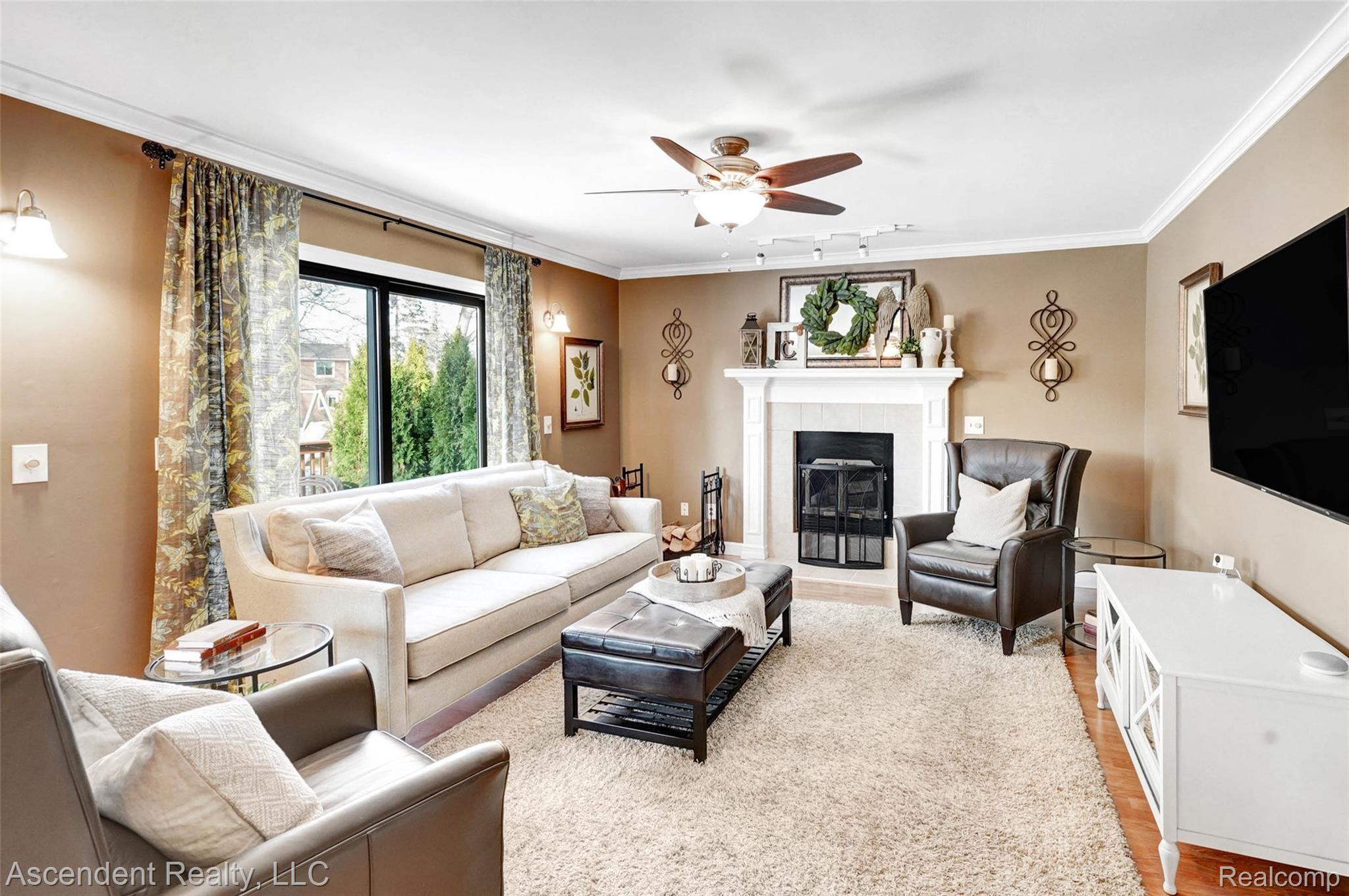 712 Dressler Lane Rochester, MI 48307 - Photo 13 of 30 Family room with newer crown and floor moldings, mantle, ceiling fan, and hardwood flooring.