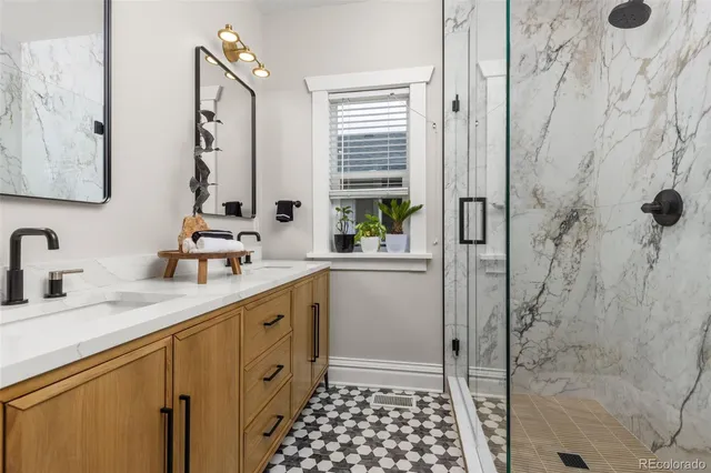 a bathroom with a double vanity sink a mirror and shower