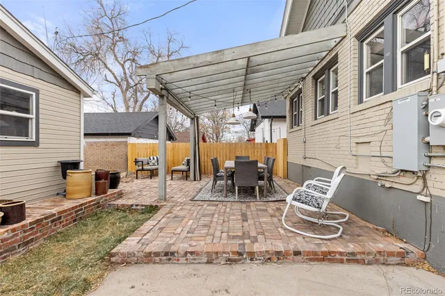 a view of a patio with table and chairs with wooden floor and fence