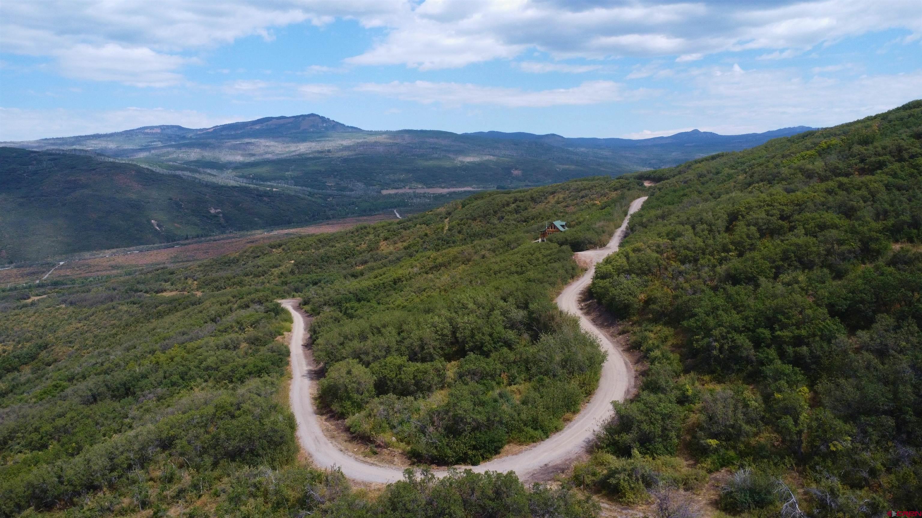 Lot 37 Stoney Creek Ranch Road Hotchkiss, CO 81419 - Photo 17 of 17 a view of a lush green hillside and a building in the background