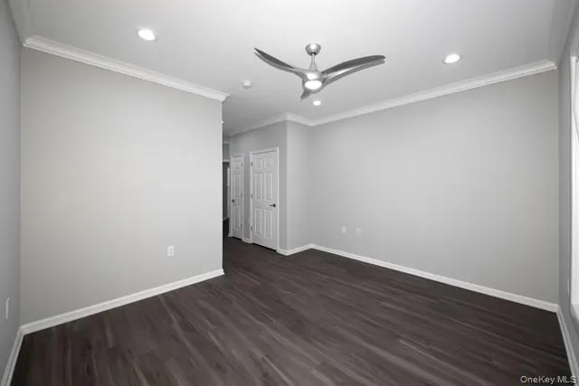 an empty room with wooden floor and a ceiling fan