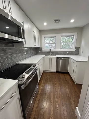 a kitchen with a sink stove and cabinets