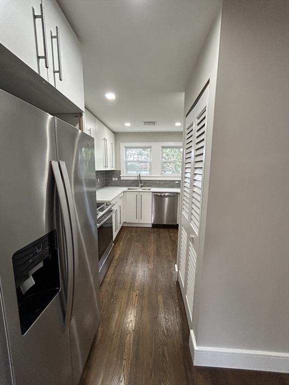 9 Hawthorne Road, Unit 2 Gloucester, MA 01930 - Photo 5 of 9 a kitchen with stainless steel appliances granite countertop a refrigerator a sink dishwasher a stove and white countertops with wooden floor