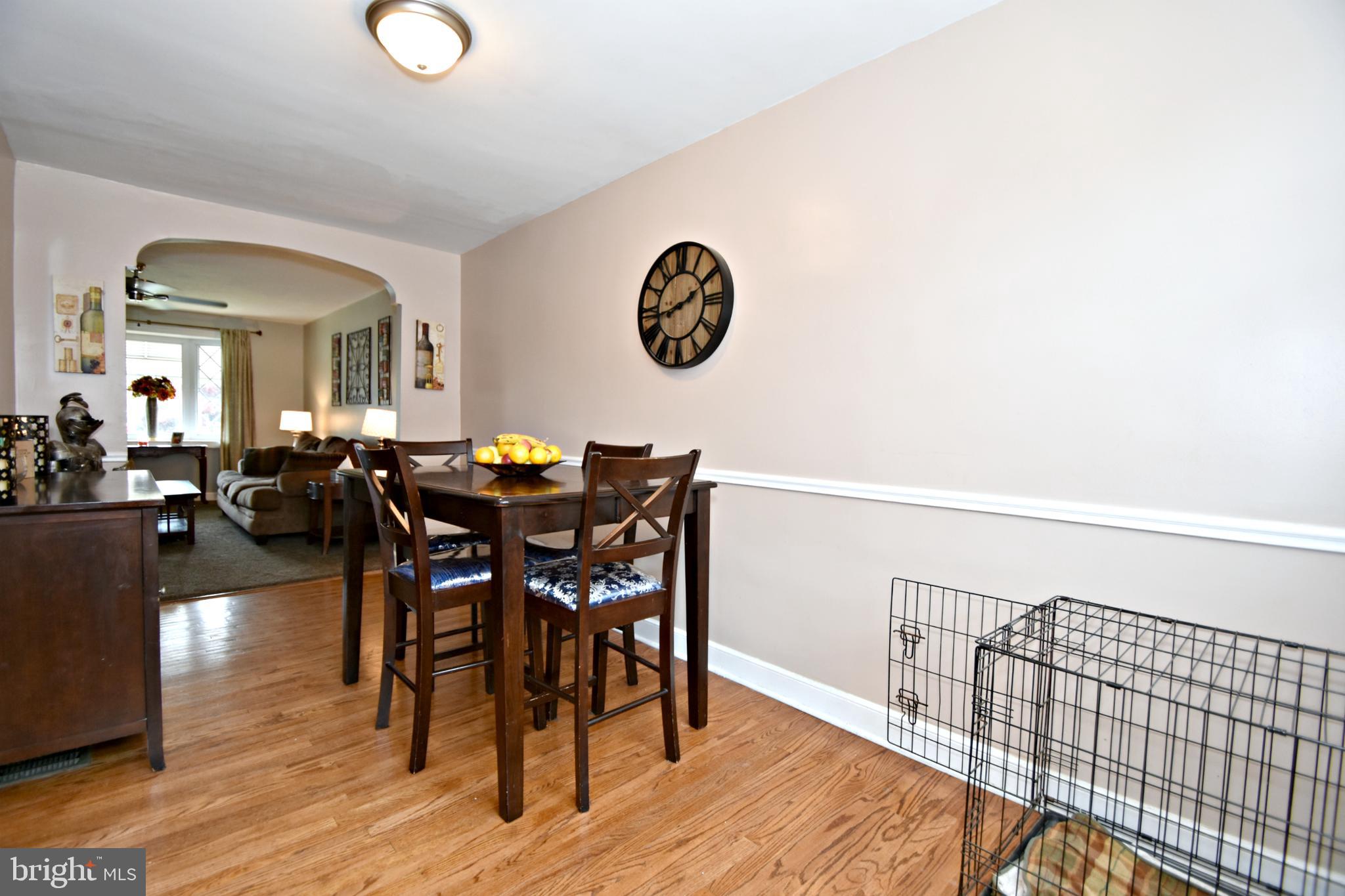 6622 Algard Street Philadelphia, PA 19135 - Photo 11 of 30 a view of a dining room and livingroom with furniture wooden floor a rug and a chandelier