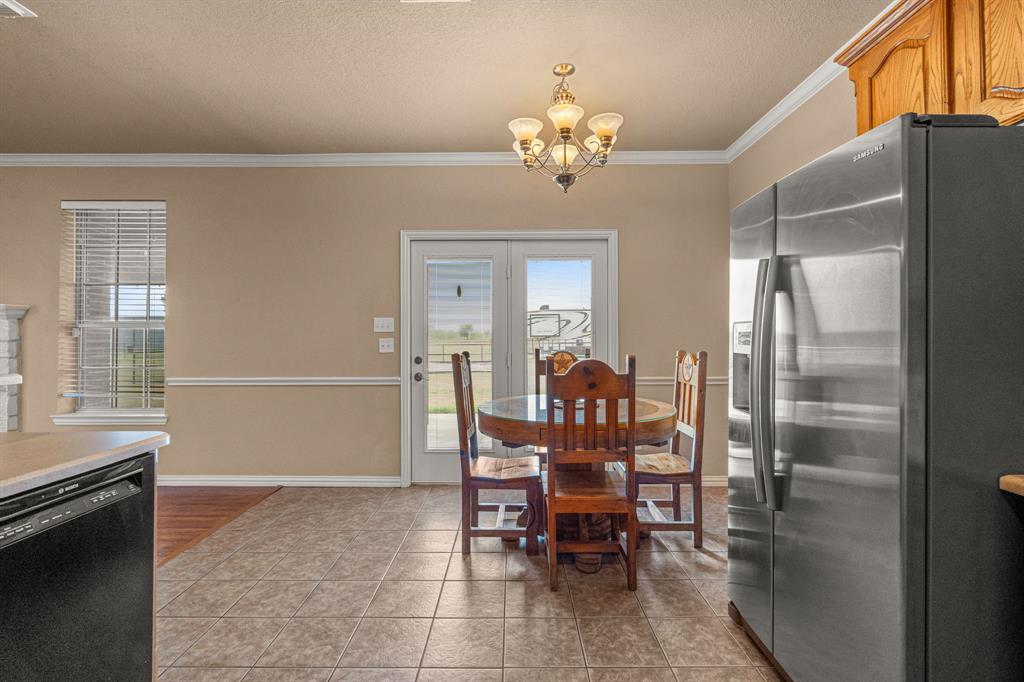 6501 Indian Trail Sanger, TX 76266 - Photo 13 of 40 Dining area with ornamental molding, a textured ceiling, light tile patterned flooring, and a chandelier