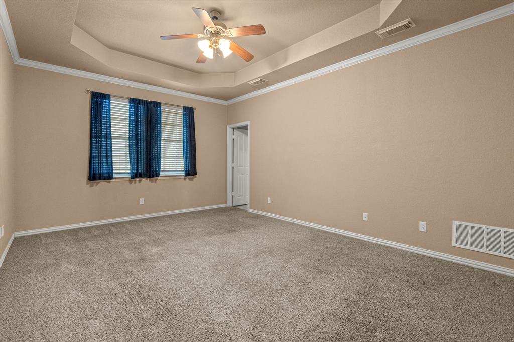6501 Indian Trail Sanger, TX 76266 - Photo 21 of 40 Carpeted spare room featuring a tray ceiling, crown molding, and a ceiling fan