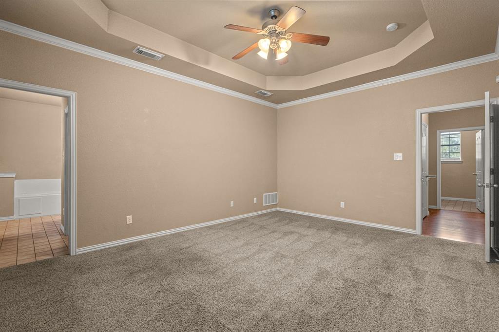 6501 Indian Trail Sanger, TX 76266 - Photo 22 of 40 Unfurnished bedroom with crown molding, a raised ceiling, light colored carpet, and a ceiling fan