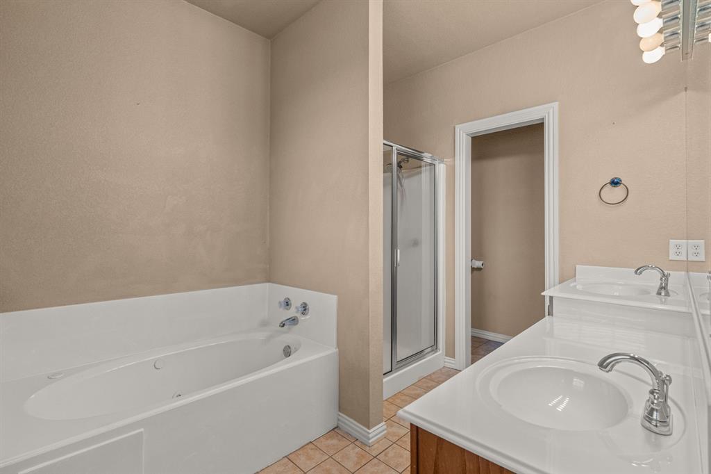 6501 Indian Trail Sanger, TX 76266 - Photo 25 of 40 Bathroom featuring light tile patterned flooring, a bath, double vanity, and a shower stall