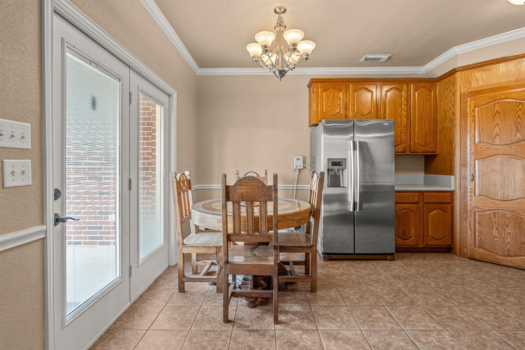 6501 Indian Trail Sanger, TX 76266 - Photo 10 of 40 Dining area with a chandelier, ornamental molding, and light tile patterned floors