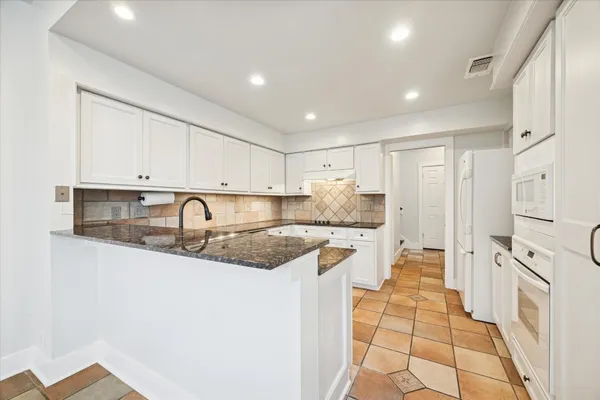 a spacious bathroom with a granite countertop sink a large mirror and a toilet