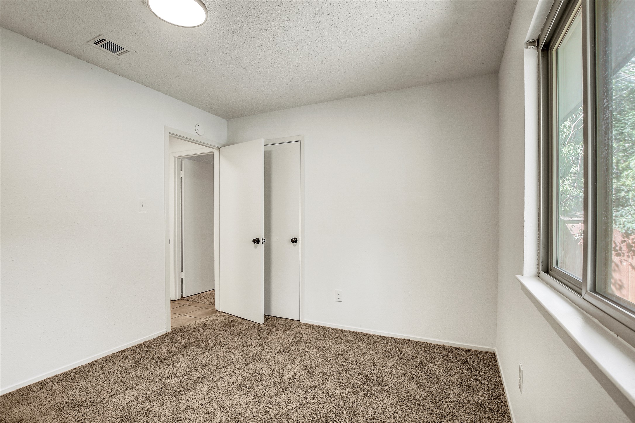 902 King Albert Street, Unit B Austin, TX 78745 - Photo 11 of 16 Carpeted spare room with a textured ceiling and baseboards