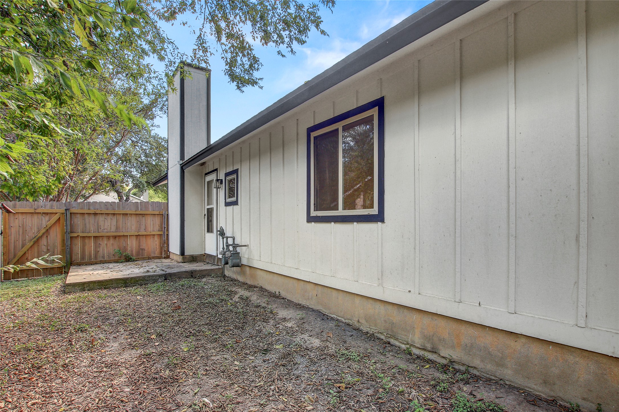 902 King Albert Street, Unit B Austin, TX 78745 - Photo 15 of 16 View of home's exterior with a chimney, a patio, and a gate