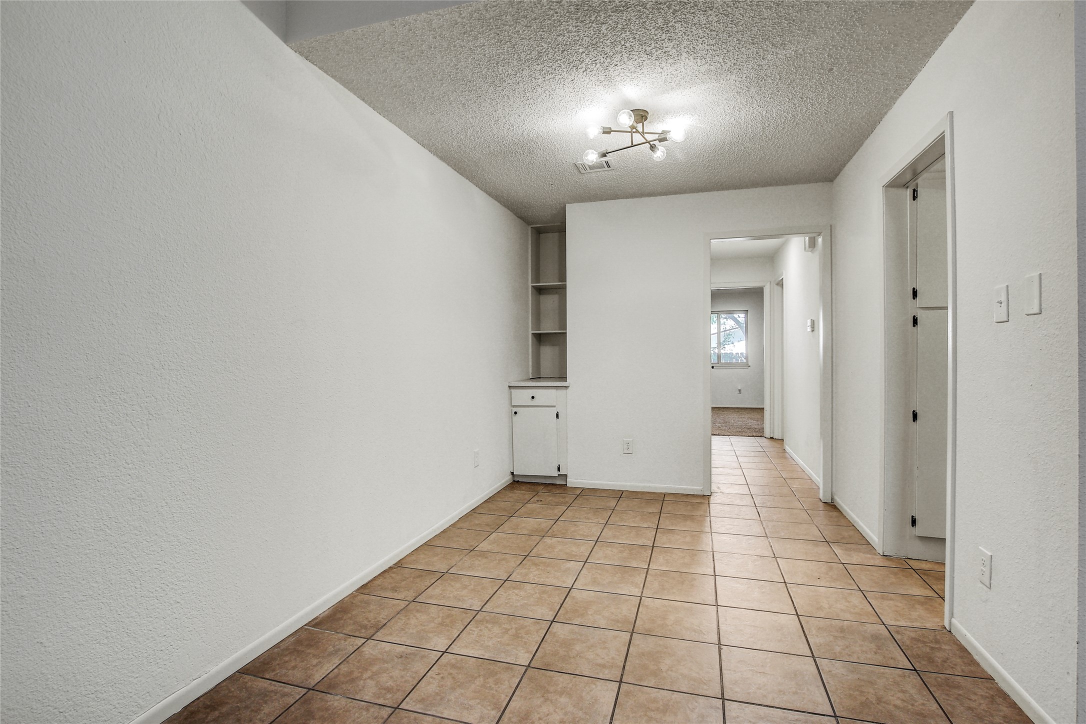 902 King Albert Street, Unit B Austin, TX 78745 - Photo 5 of 16 Spare room with a textured ceiling, a textured wall, and light tile patterned flooring