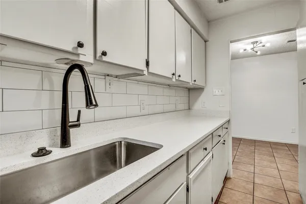 a close view of a sink a faucet and appliances in a kitchen