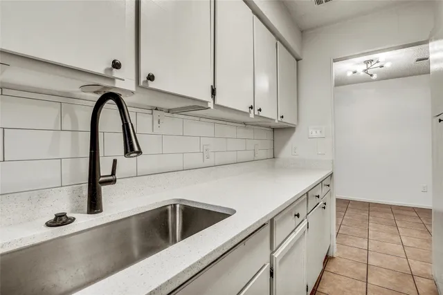 a close view of a sink a faucet and appliances in a kitchen