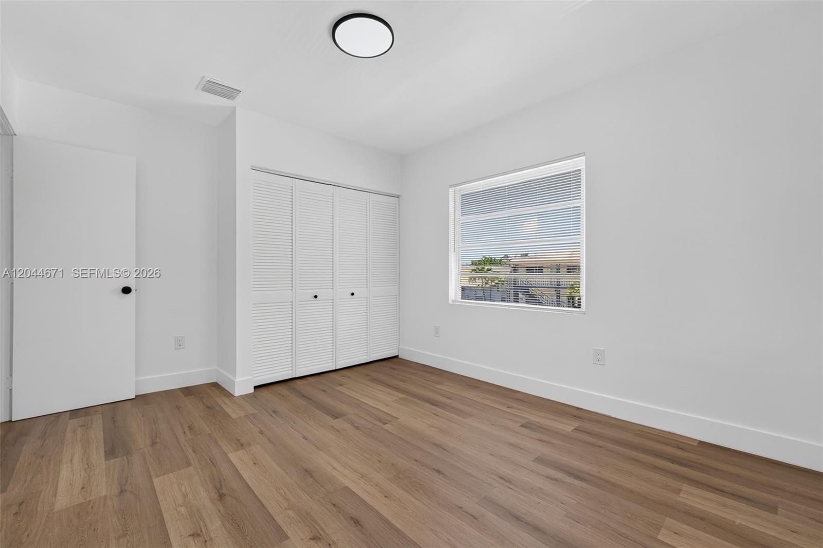 1900 Southwest 6th Street, Unit 6 Miami, FL 33135 - Photo 14 of 20 a view of an empty room with wooden floor and a window