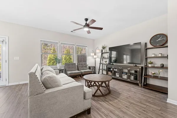 a living room with furniture a flat screen tv and a large window