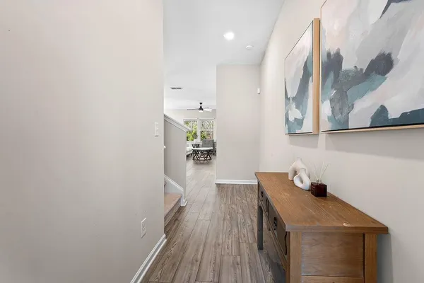 a hallway with a sink and wooden floor