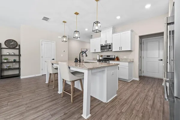 a kitchen with a sink a counter space and wooden floor