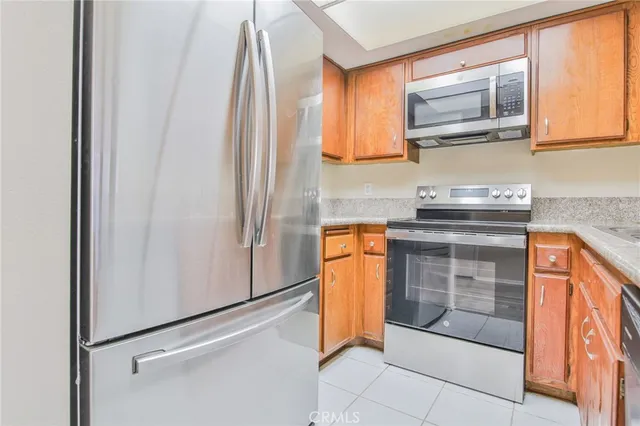 a kitchen with stainless steel appliances granite countertop a refrigerator and a stove top oven