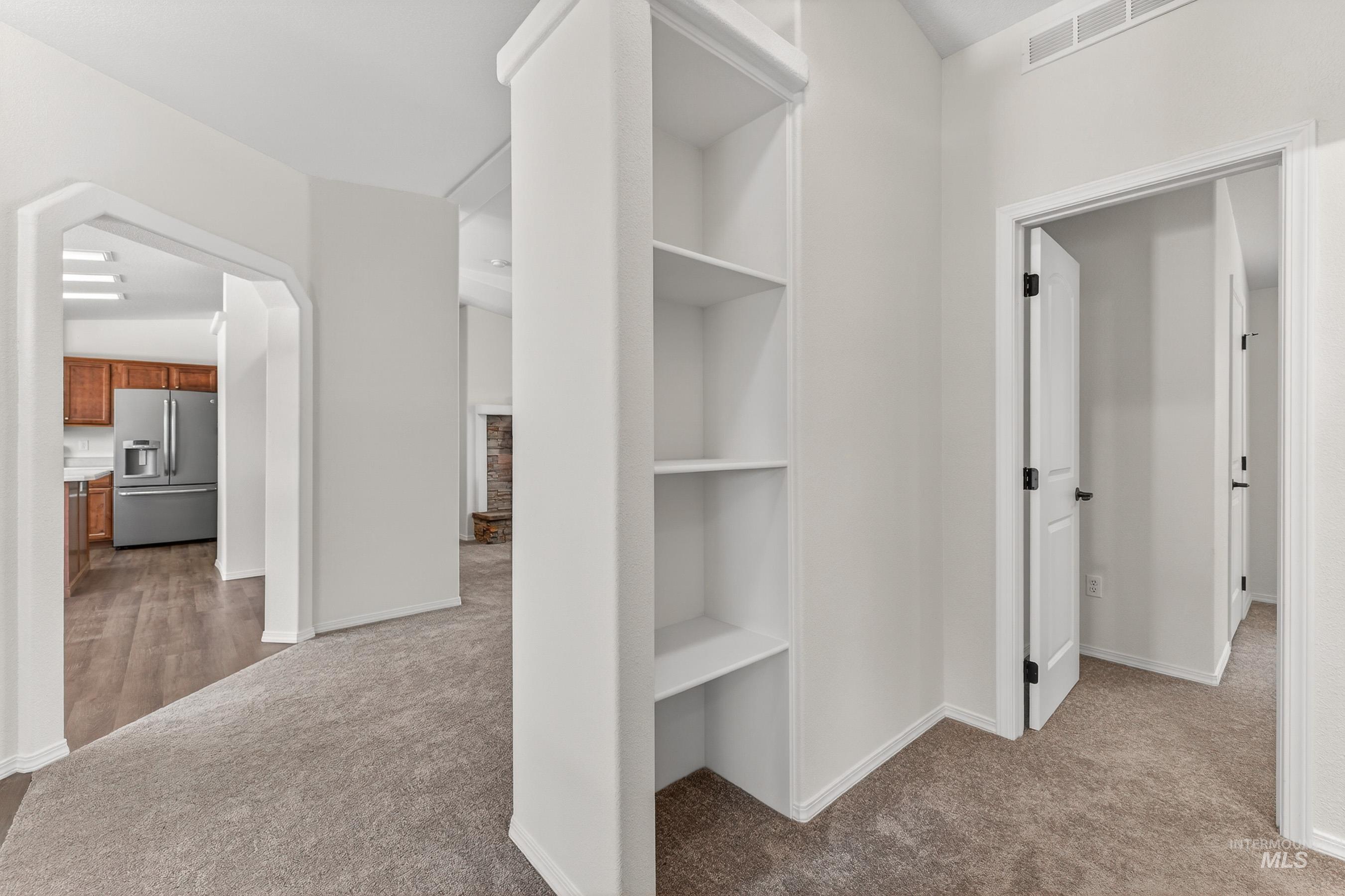 1649 Crown Point Parkway Cascade, ID 83611 - Photo 13 of 24 Hallway featuring built-in shelving, neutral carpeting, and white painted walls