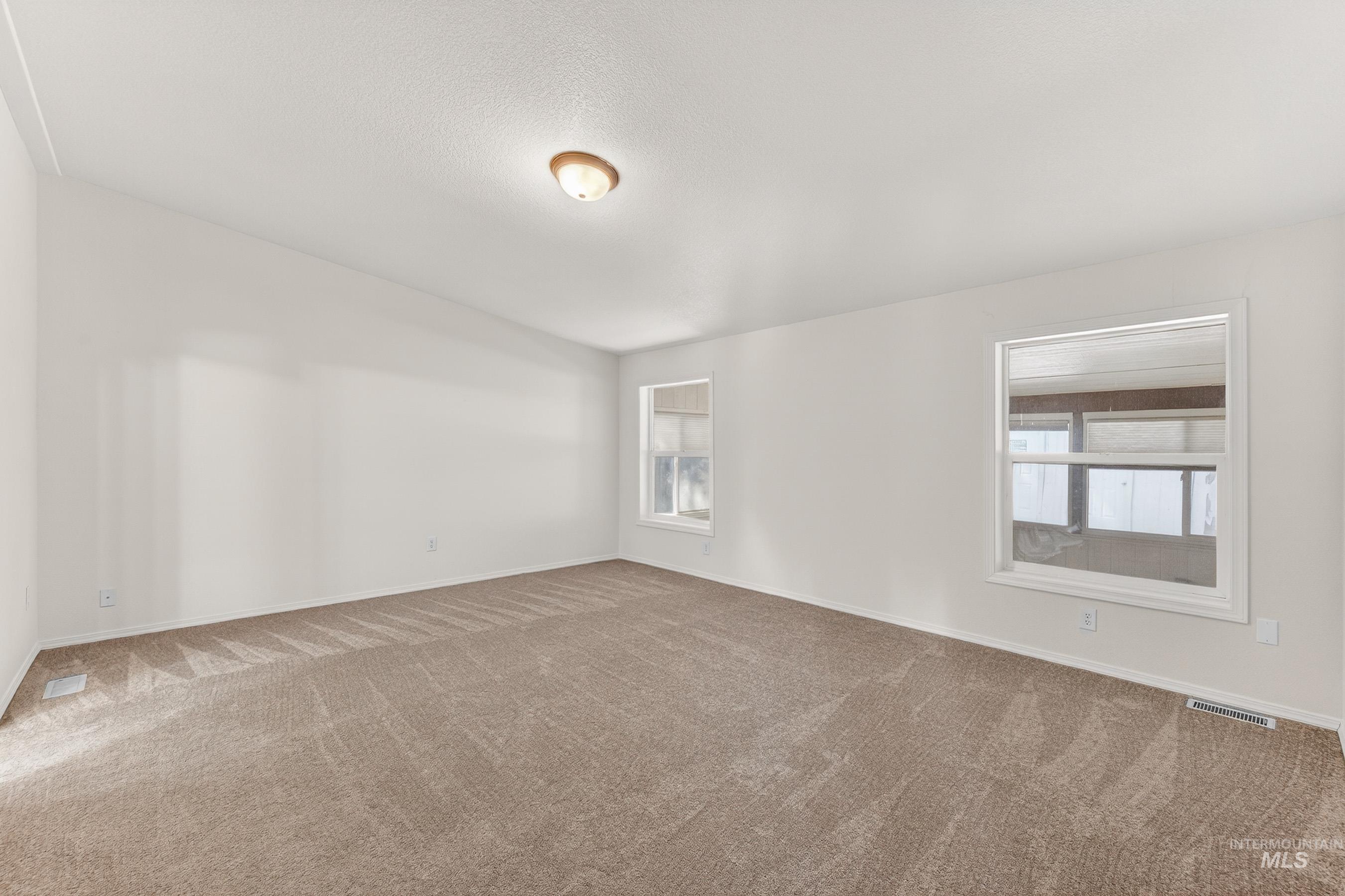 1649 Crown Point Parkway Cascade, ID 83611 - Photo 14 of 24 Spacious room featuring neutral carpeting, white painted walls, and an overhead flush-mount light fixture