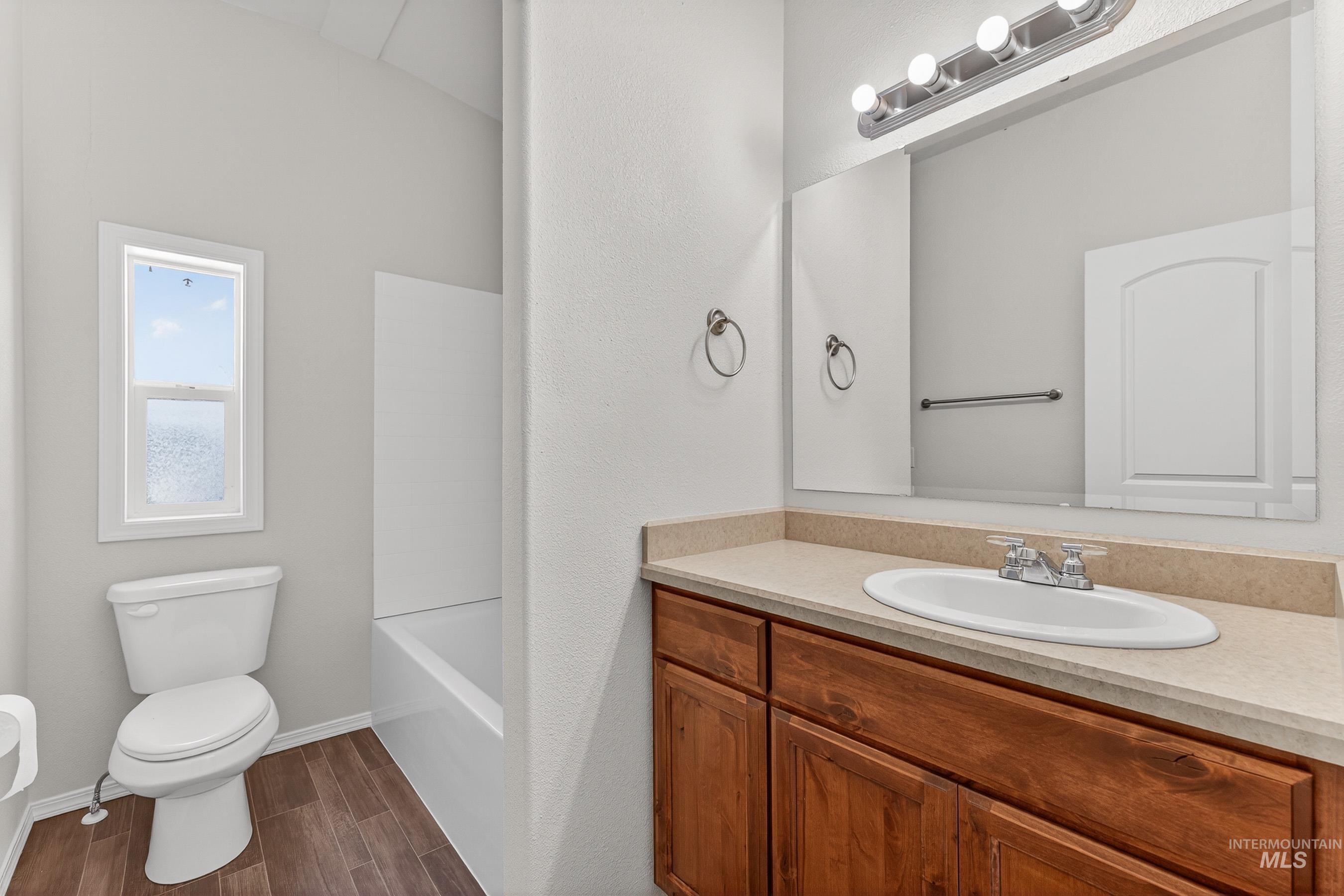 1649 Crown Point Parkway Cascade, ID 83611 - Photo 15 of 24 Bathroom featuring a vanity with a light-toned countertop, wood-finish cabinetry, and an oval undermount sink