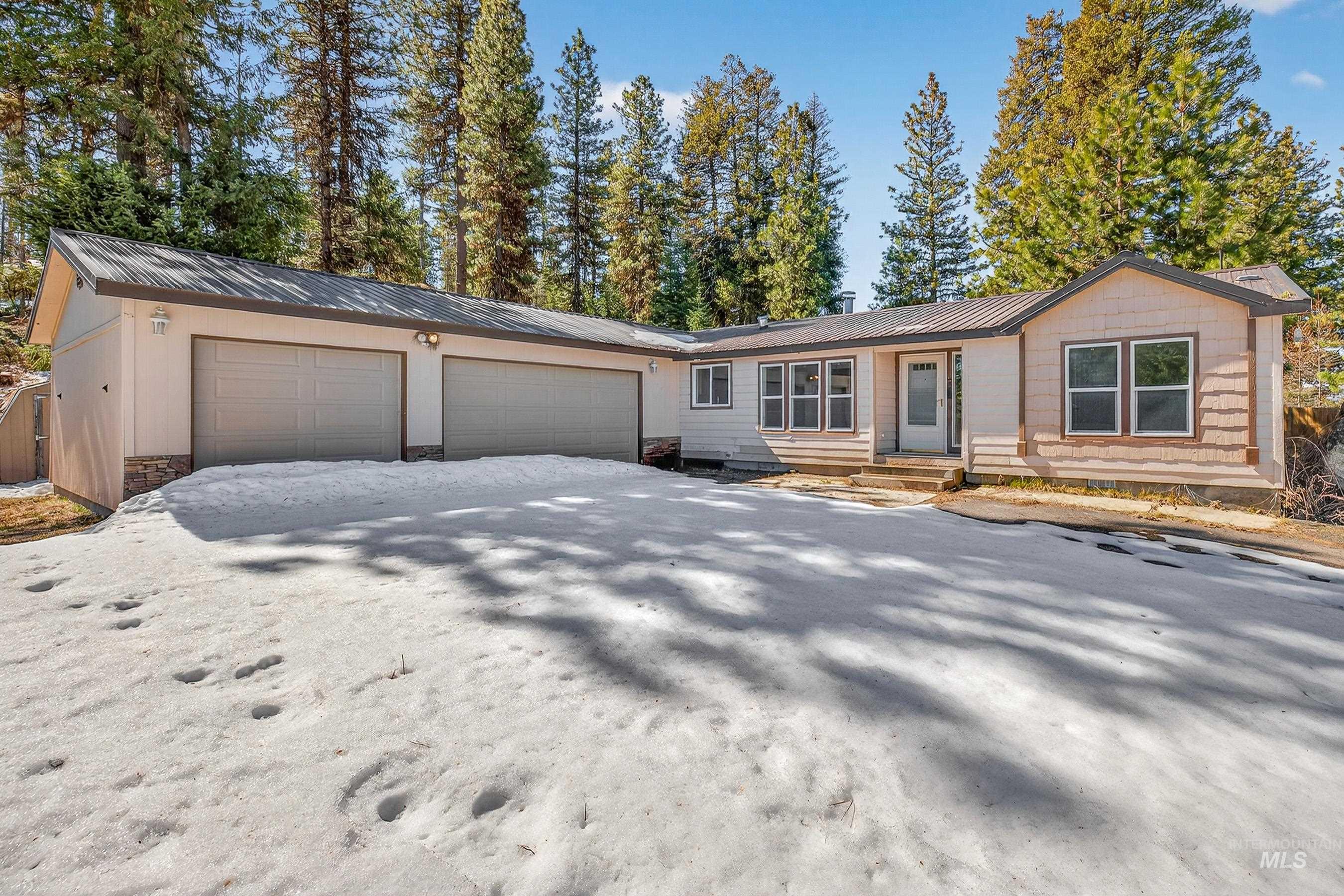 1649 Crown Point Parkway Cascade, ID 83611 - Photo 24 of 24 Exterior showcasing a two-car garage with overhead doors, a covered entry, and multiple windows