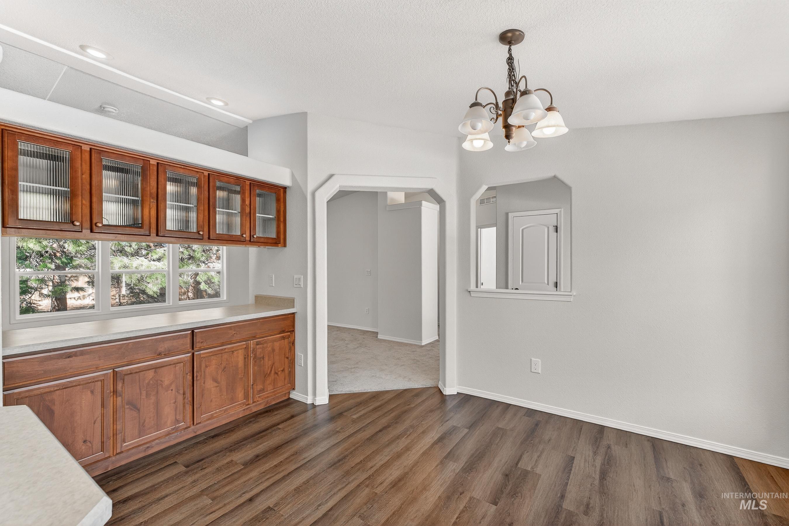 1649 Crown Point Parkway Cascade, ID 83611 - Photo 5 of 24 Kitchenette featuring wood-finish lower cabinetry, glass-front upper cabinetry, and a light-toned countertop