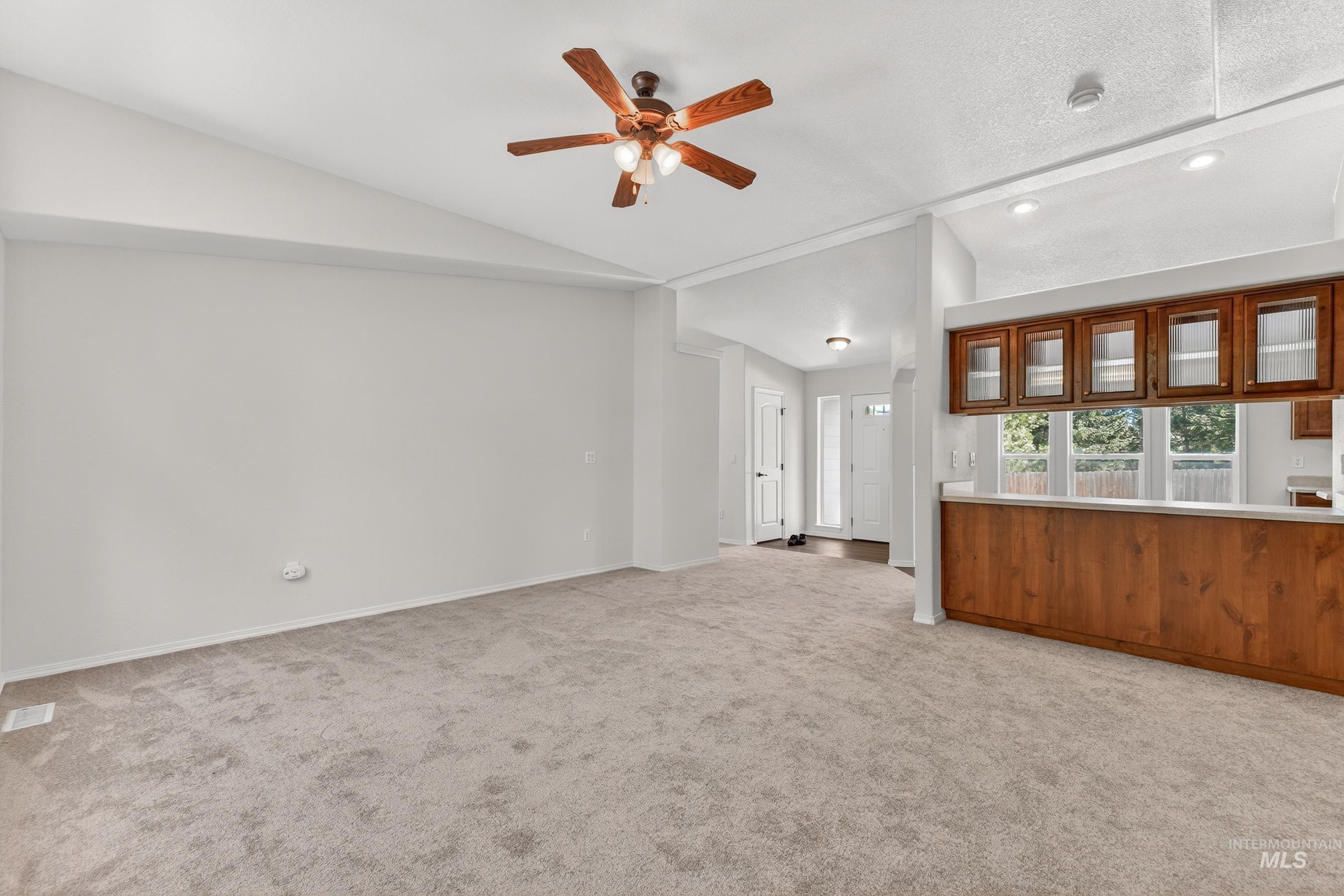 1649 Crown Point Parkway Cascade, ID 83611 - Photo 10 of 24 Spacious living area featuring vaulted ceilings, light-toned carpeting, and a ceiling fan with integrated lighting