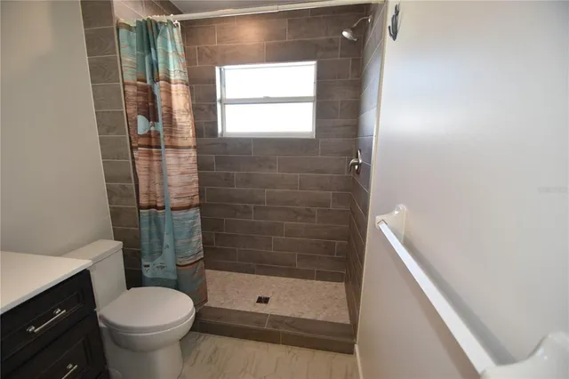 a bathroom with a toilet and a shower