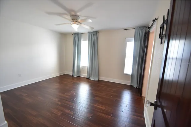 an empty room with wooden floor and window