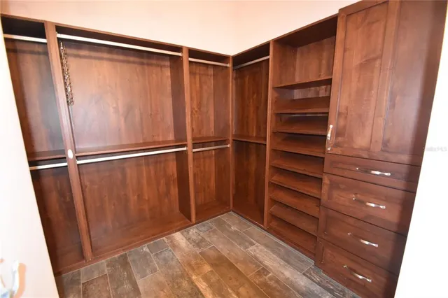 a large white kitchen with a refrigerator a sink dishwasher a stove and white countertops with wooden floor