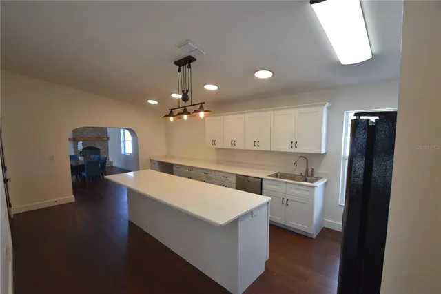 a kitchen with stainless steel appliances a refrigerator sink and cabinets