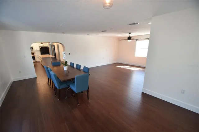 an empty room with windows and fan view