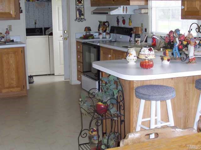 121 My Country Road Roxboro, NC 27574 - Photo 3 of 9 a kitchen with stainless steel appliances a sink cabinets and a dining table