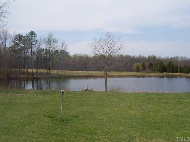 121 My Country Road Roxboro, NC 27574 - Photo 8 of 9 a backyard of a house with lots of green space and lake view