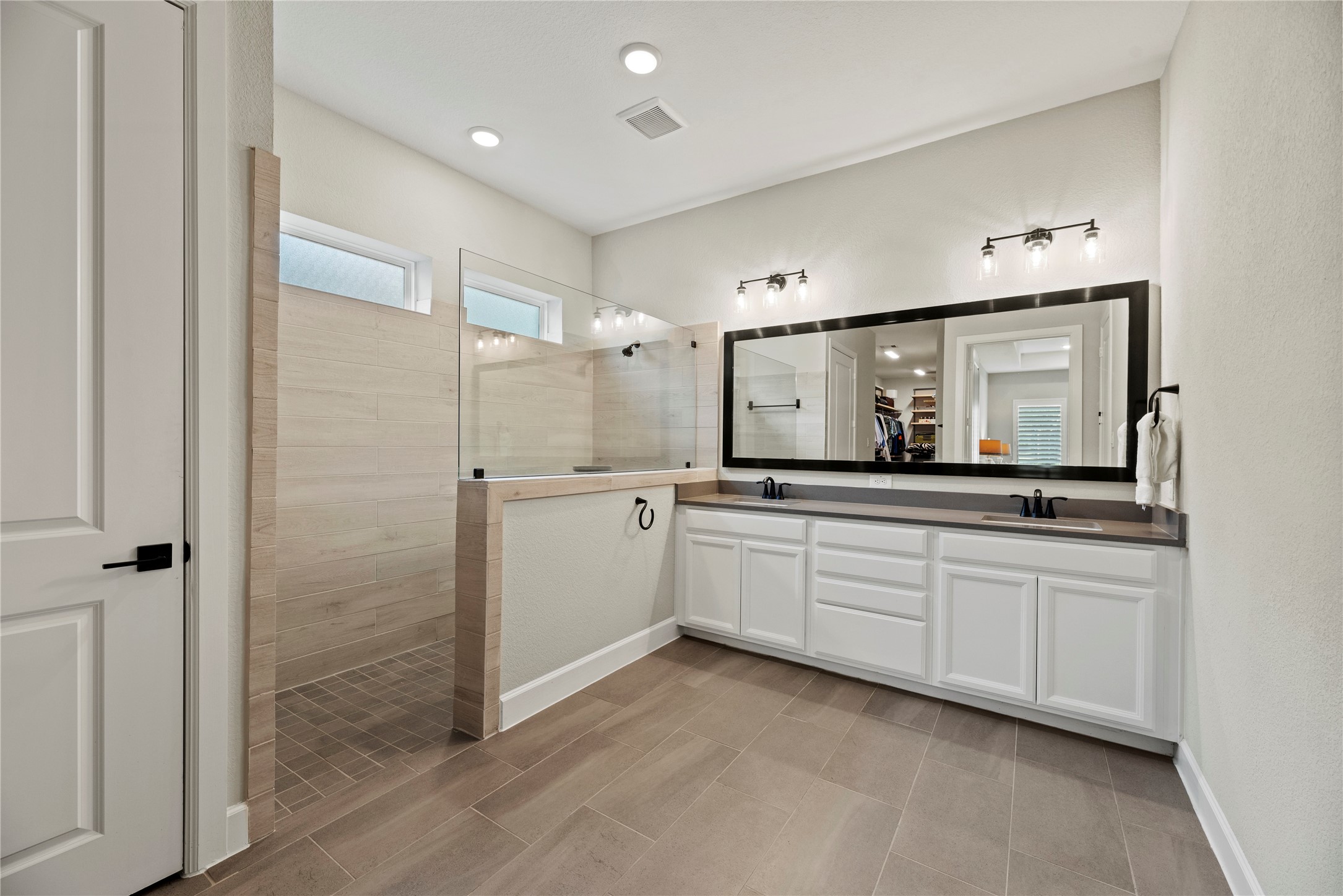7543 Congress Trail Way Porter, TX 77365 - Photo 22 of 45 a bathroom with a double vanity sink mirror and shower