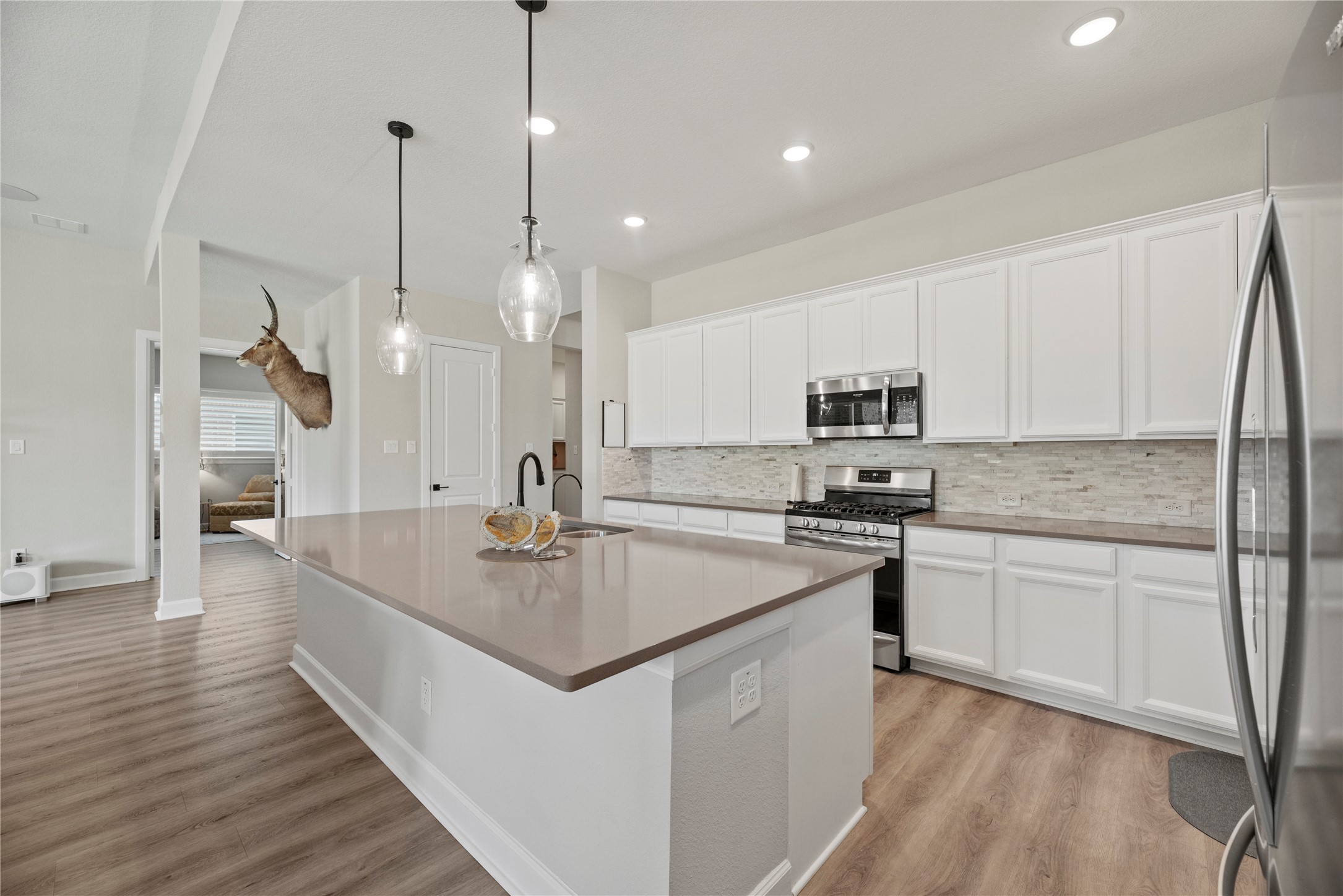 7543 Congress Trail Way Porter, TX 77365 - Photo 25 of 45 a kitchen with stainless steel appliances granite countertop a sink a stove and a wooden floors