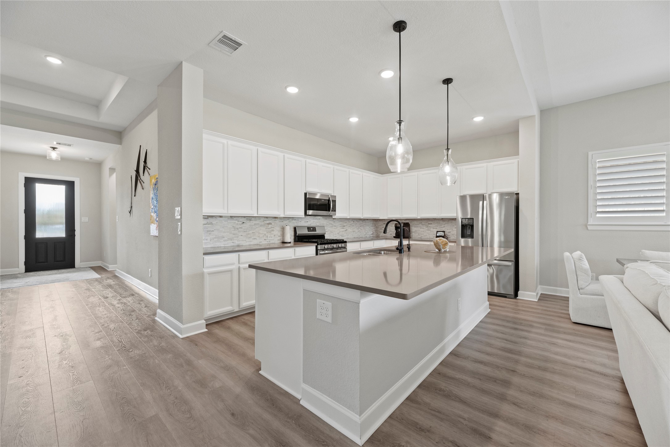 7543 Congress Trail Way Porter, TX 77365 - Photo 7 of 45 a large white kitchen with kitchen island a sink a center island stainless steel appliances and a window