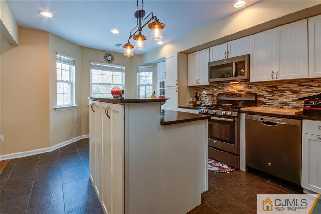191 Nebula Road, Unit 191 Piscataway, NJ 08854 - Photo 6 of 24 a kitchen with stainless steel appliances granite countertop a stove top oven a sink dishwasher a refrigerator and a microwave oven with wooden floor