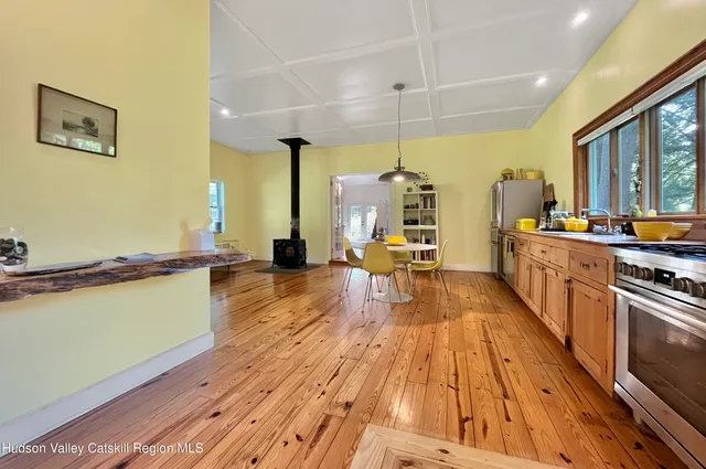 a kitchen with stainless steel appliances kitchen island granite countertop a table chairs and a refrigerator