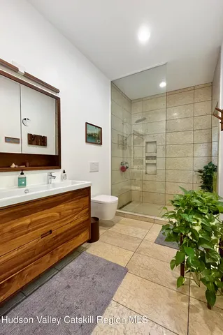 a bathroom with a granite countertop sink a mirror and shower