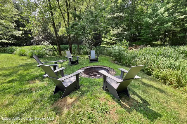 a view of a mini theater with a yard and large trees