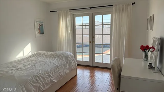a spacious bedroom with a balcony a bed and a window