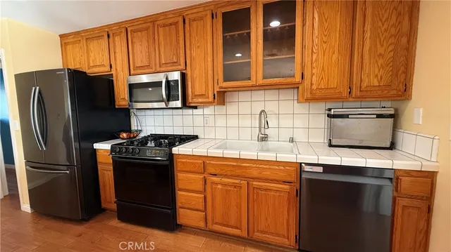 a kitchen with stainless steel appliances granite countertop a refrigerator stove and sink