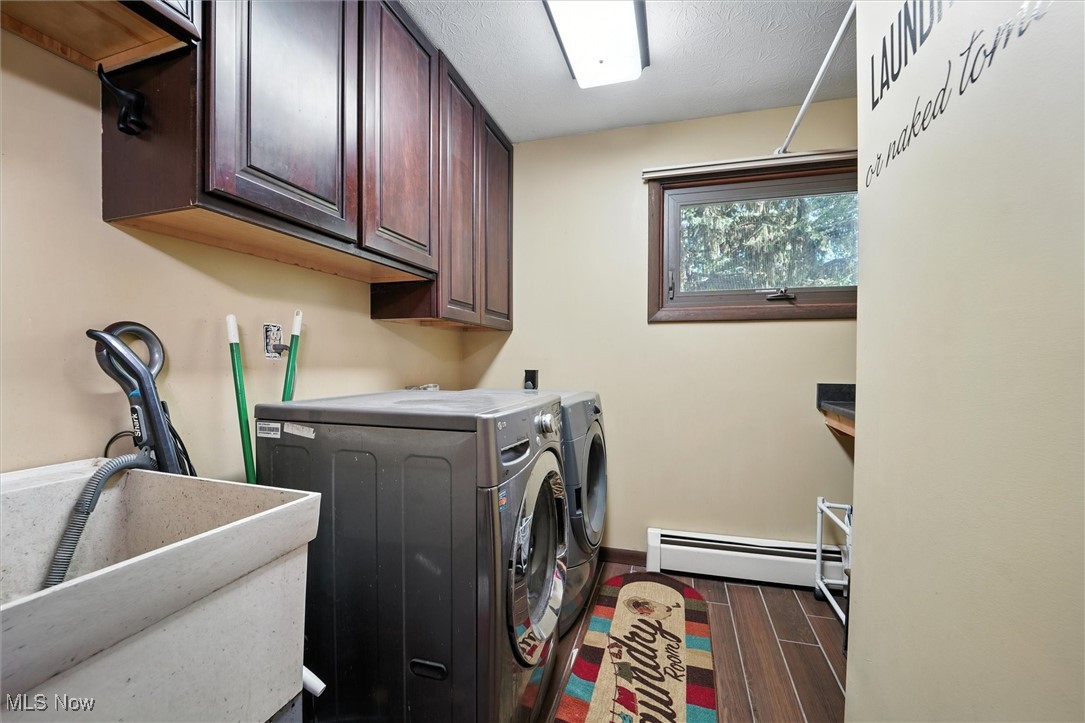 12120 Caves Road Chesterland, OH 44026 - Photo 37 of 50 Laundry room featuring cabinet space, a baseboard heating unit, wood finish floors, independent washer and dryer, and a textured ceiling