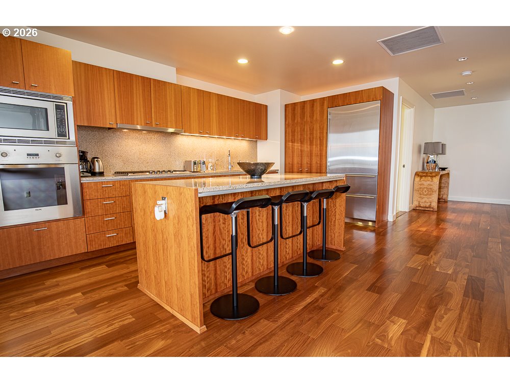 841 Southwest Gaines Street, Unit 2012 Portland, OR 97239 - Photo 21 of 44 a kitchen with stainless steel appliances granite countertop a stove a sink and a refrigerator