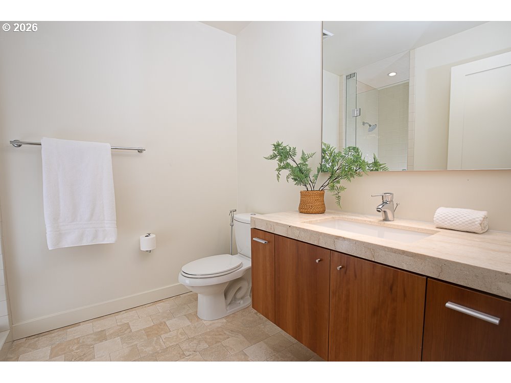 841 Southwest Gaines Street, Unit 2012 Portland, OR 97239 - Photo 29 of 44 a bathroom with a granite countertop sink a toilet and a mirror