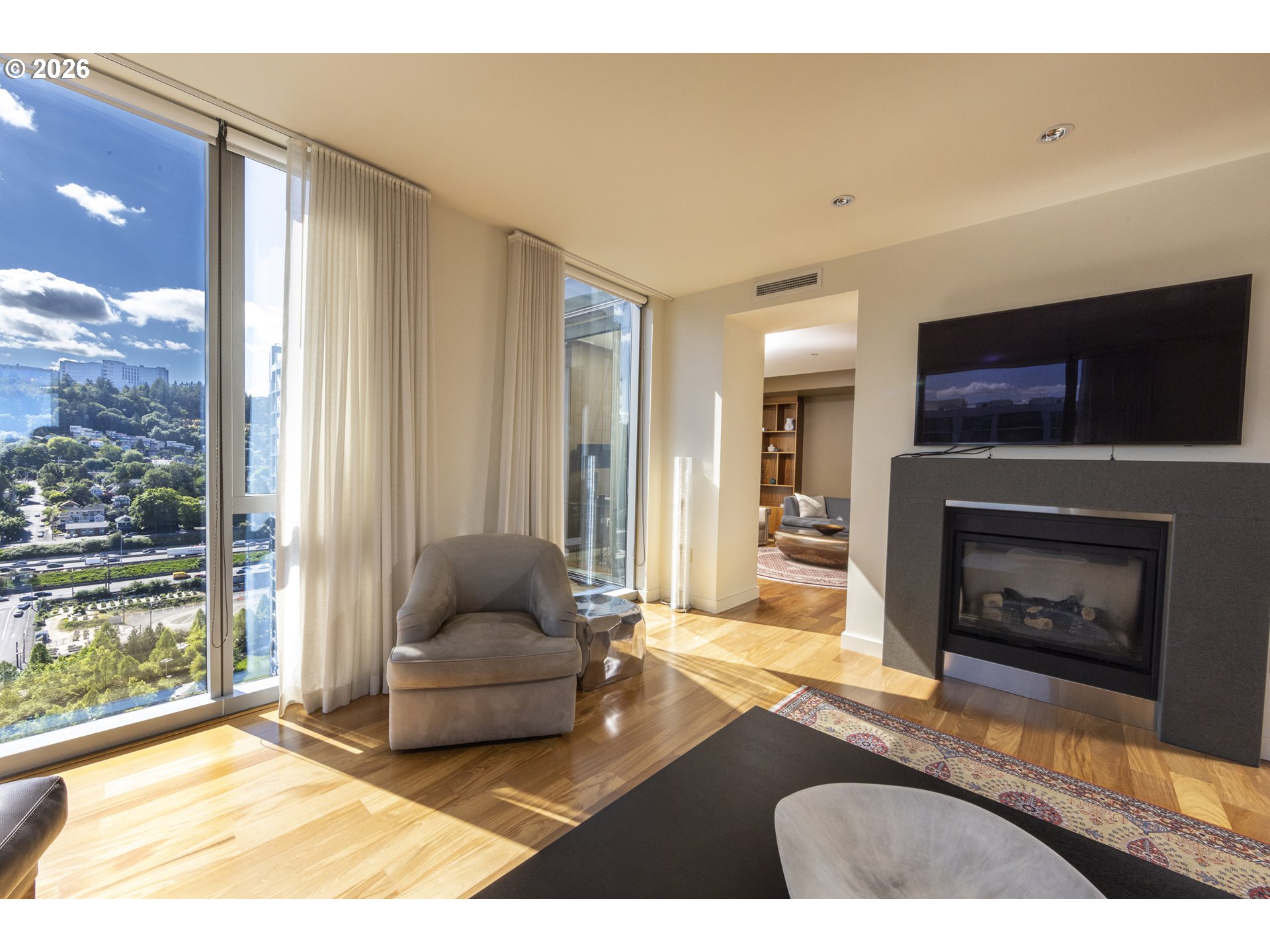 841 Southwest Gaines Street, Unit 2012 Portland, OR 97239 - Photo 8 of 44 a living room with furniture a flat screen tv and a fireplace